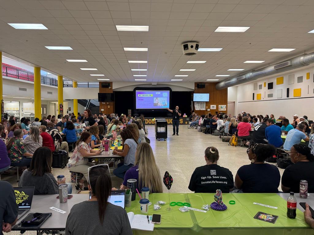 Stephen J. Barnwell presenting to a large group of educators in a school cafeteria